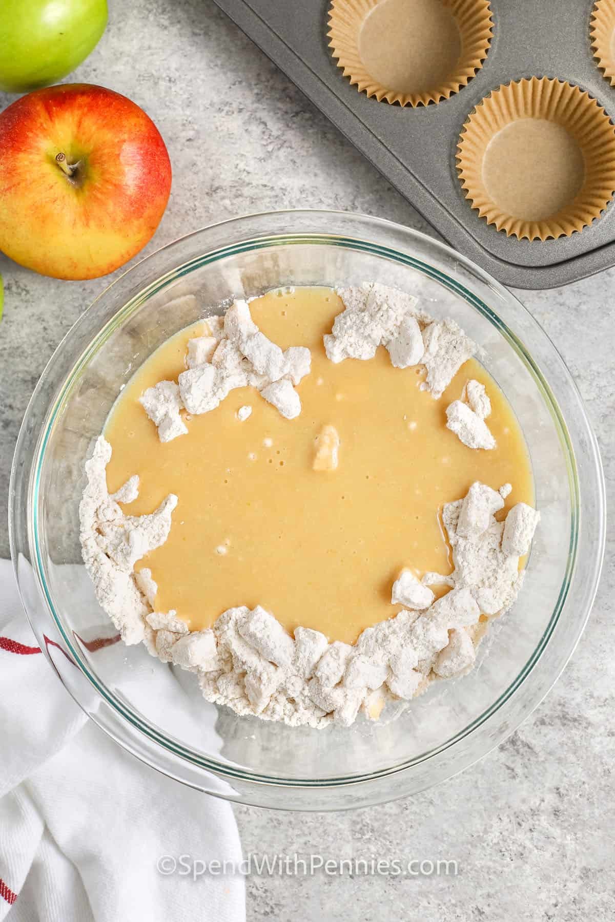 adding wet ingredients to dry ingredients to make Apple Muffins