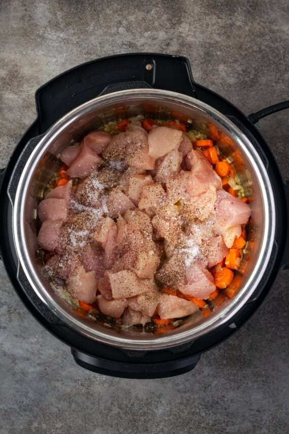 Cubed chicken added to the instant pot with sauteed veggies.