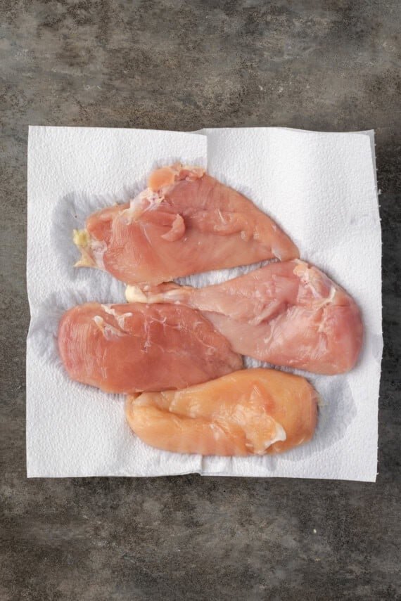 Brined chicken breasts draining on a paper towel.