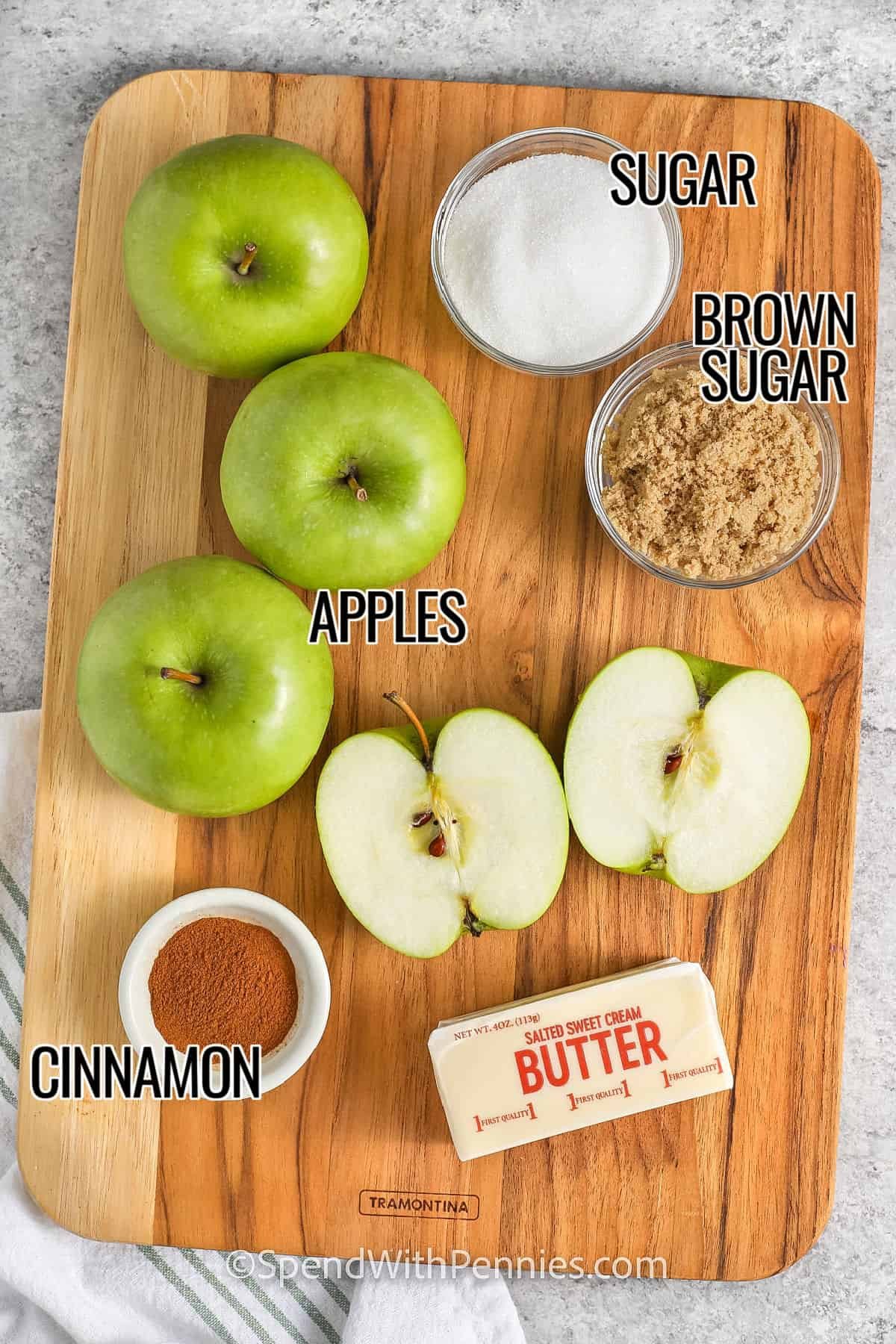 ingredients on a cutting board to make fried apples labeled: apples, sugar, brown sugar, cinnamon, butter