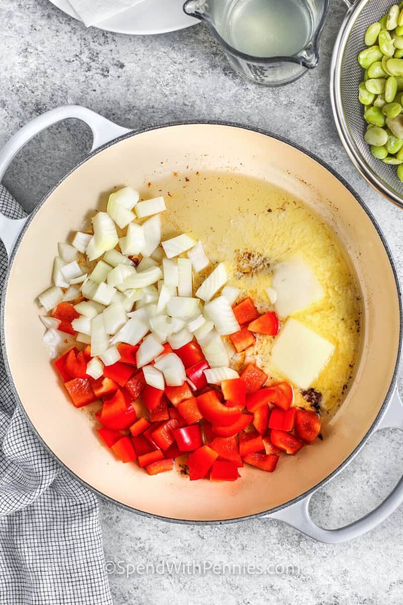 cooking peppers and onions in butter to make Succotash