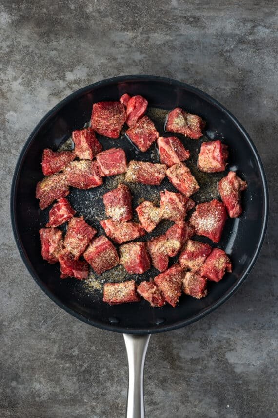 Cubed beef browning in a skillet.