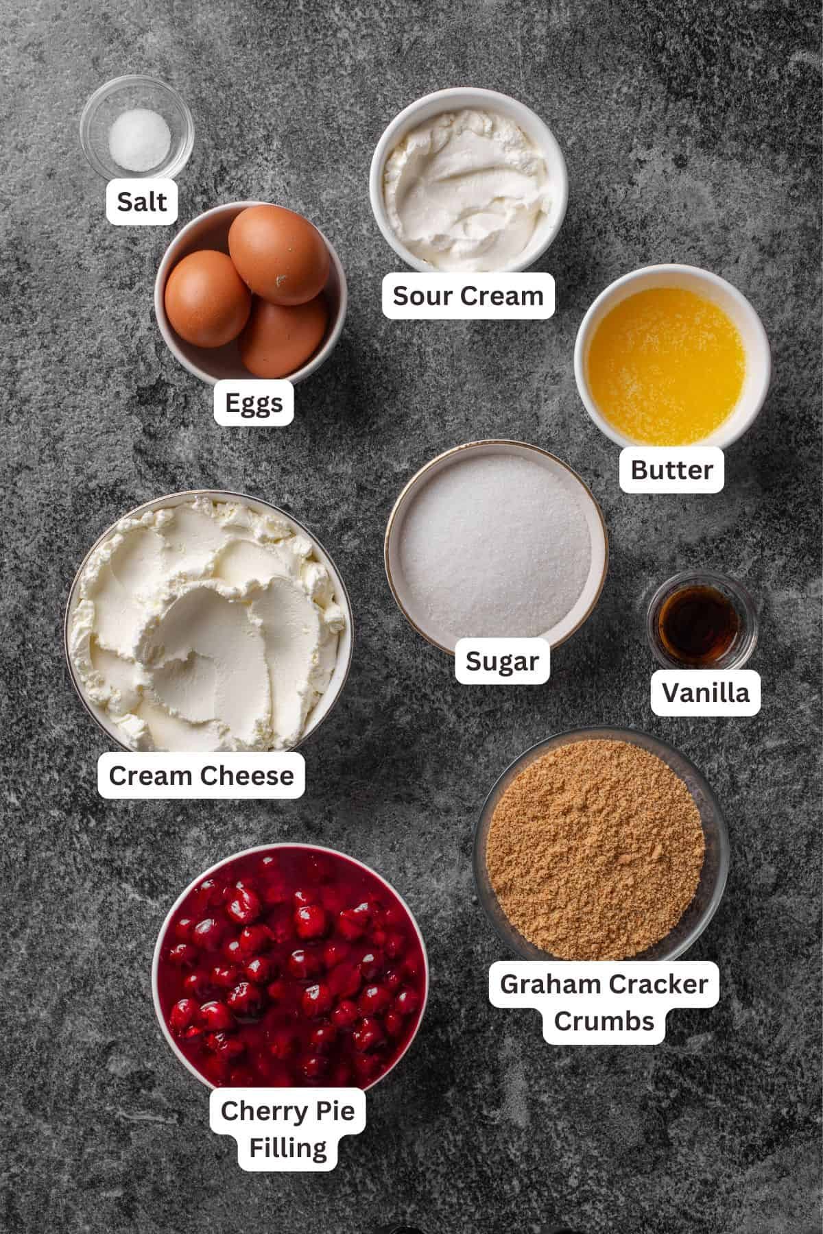 Cherry cheesecake ingredients with text labels overlaying each ingredient.