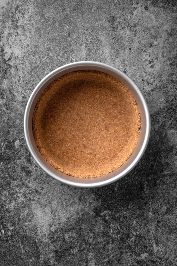 Graham cracker crust pressed into the bottom of a springform pan.