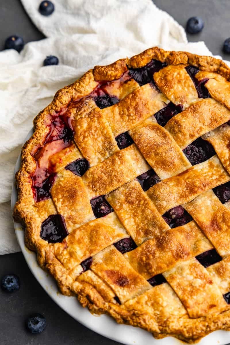 A close up overhead view of a blueberry pie with a lattice crust.