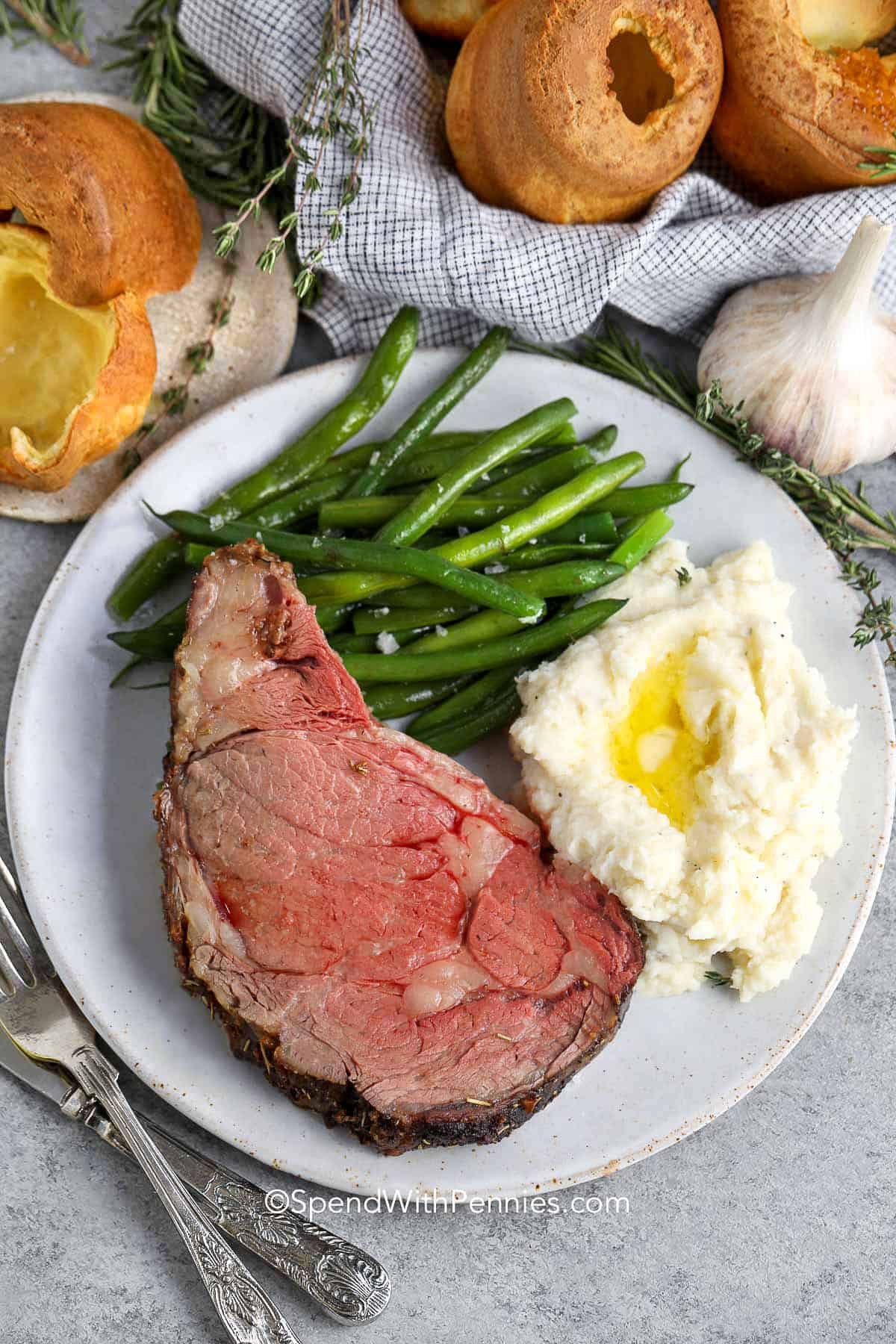 Prime Rib on a plate with mashed potatoes and green beans