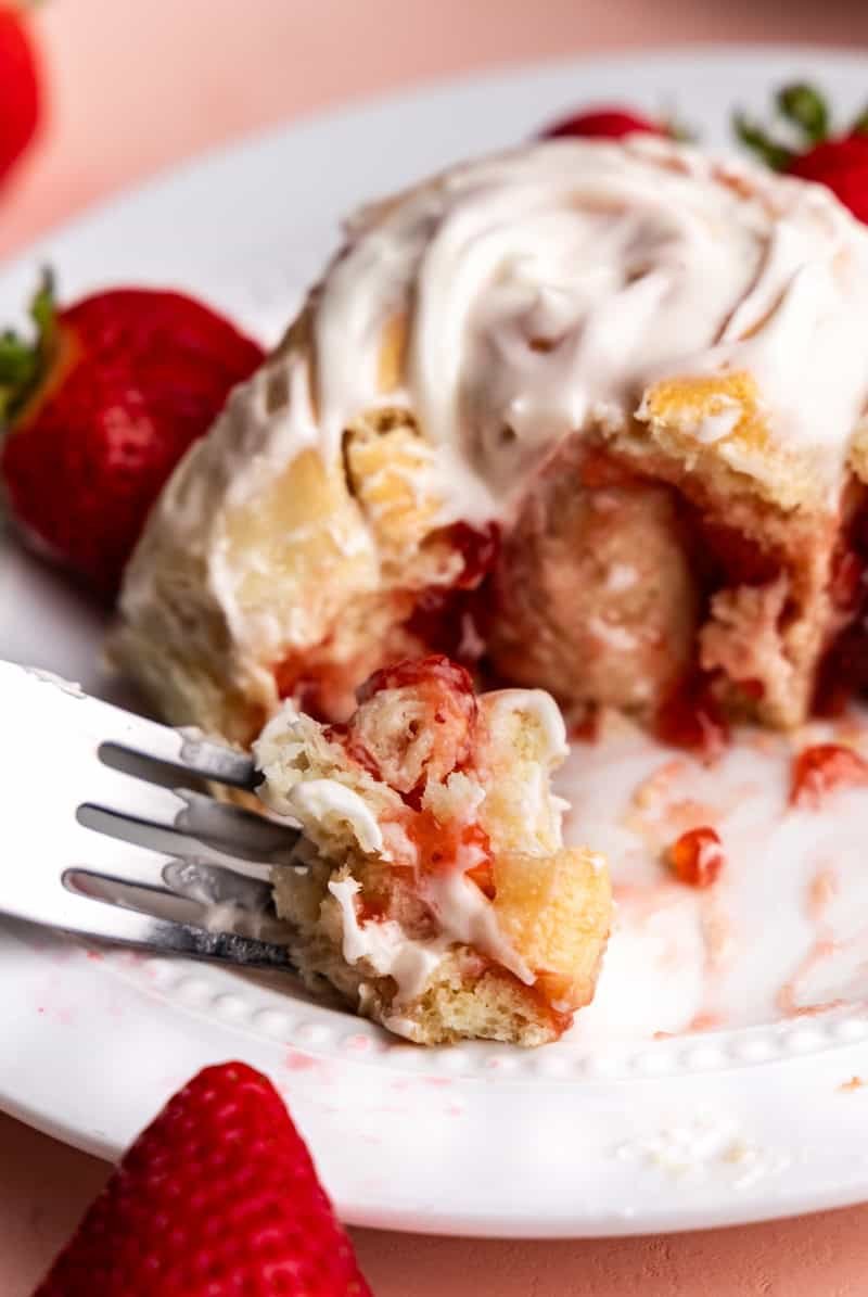 up close view of a bite of strawberry roll on a fork